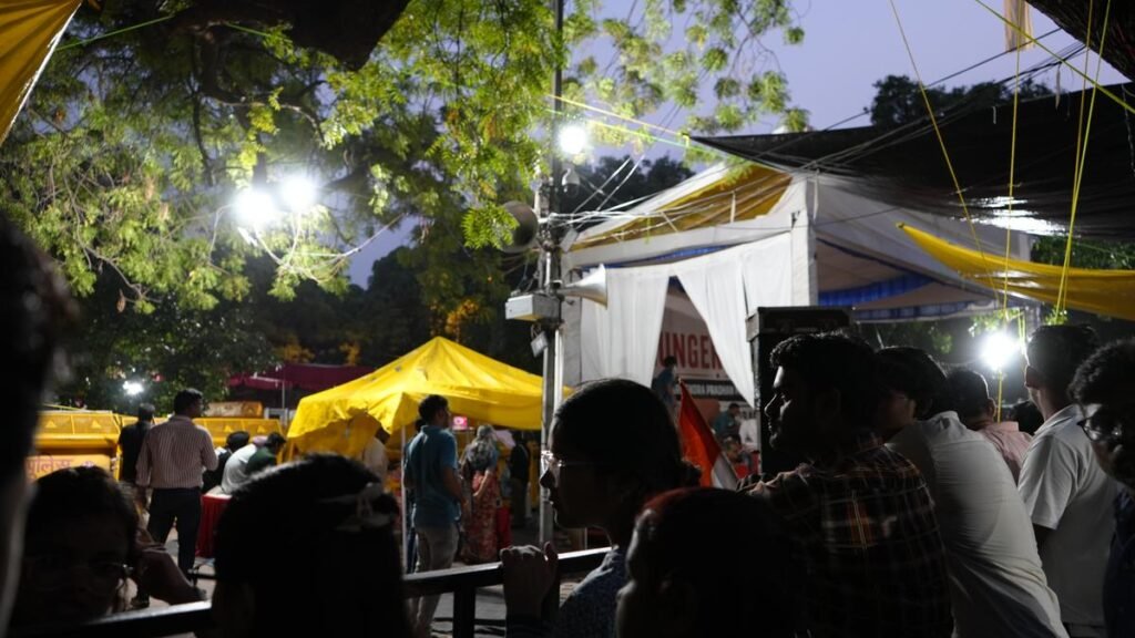Plastic sheets, hand-painted placards and rolled-up mattresses have become a ritual at Jantar Mantar. Protestors sing through the crowd with bottles of water and packets of ORS, and check on those on an indefinite hunger strike. Between speeches, students huddle under patches of shade, scrolling through old admit cards, exam notifications and messages from home.