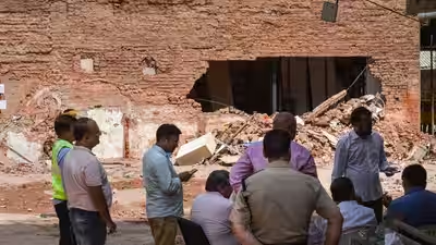 Police officials and people gather at the site during a rescue operation.